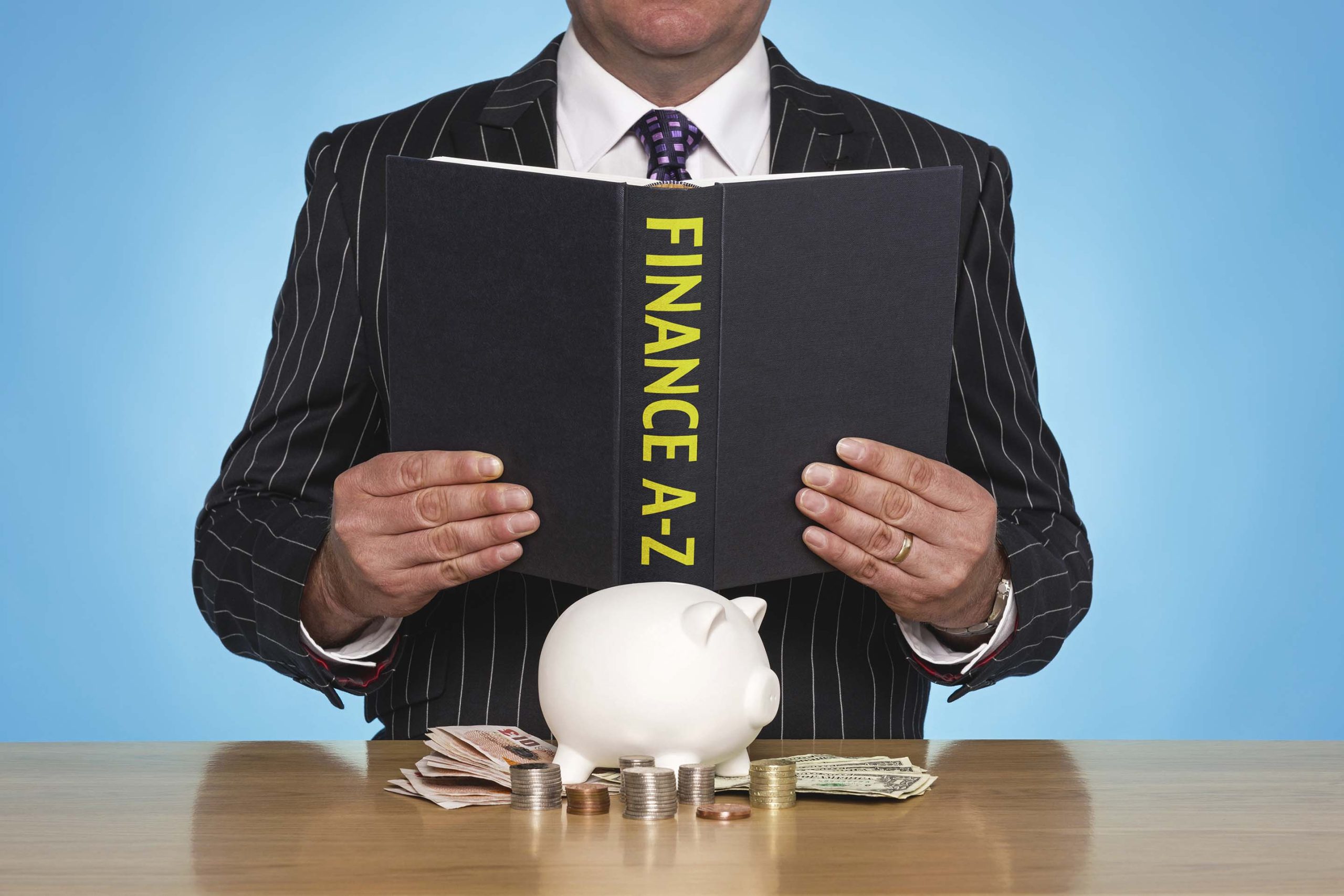 Image showing a man holding a book that says Finance A - Z on its spine.